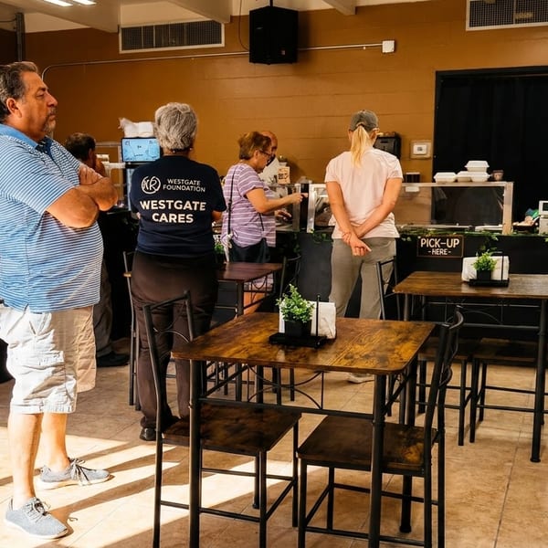 Customers wait in line at a restaurant counter with "Order Here" and "Pick-Up Here" signs.